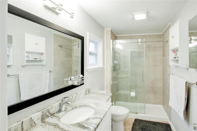 bathroom with a textured ceiling, toilet, vanity, tile patterned floors, and a stall shower