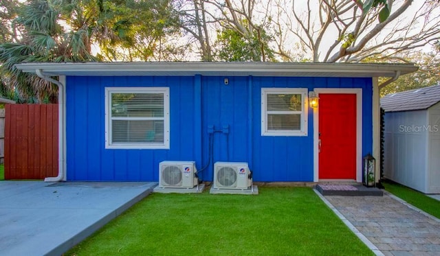 view of outbuilding with ac unit, an outdoor structure, and fence