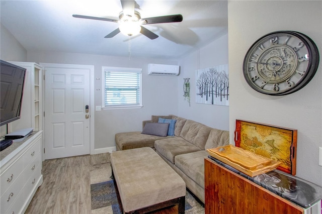 living room with a wall mounted air conditioner, ceiling fan, and light wood-style flooring