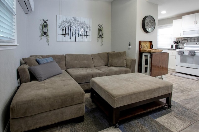 living area featuring a wall mounted air conditioner, wood finished floors, and recessed lighting