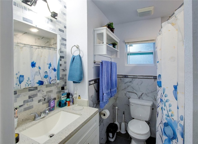 bathroom featuring tile walls, visible vents, a shower with shower curtain, toilet, and vanity