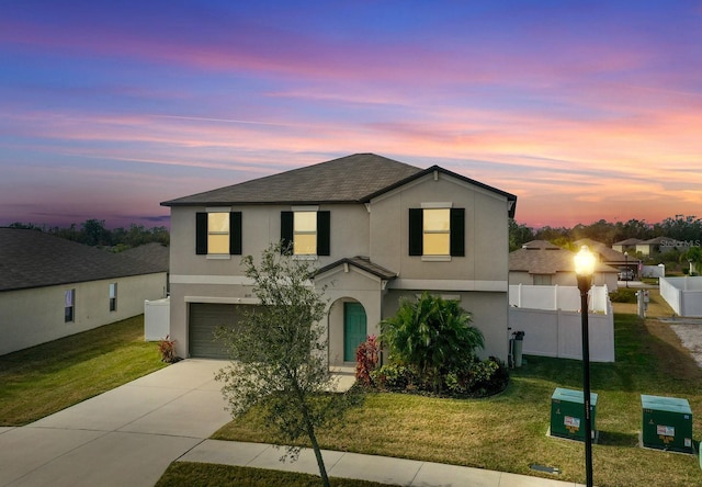 view of front of house featuring a garage and a yard