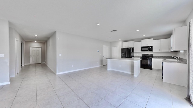 kitchen with light tile patterned flooring, sink, white cabinetry, a kitchen island, and black appliances