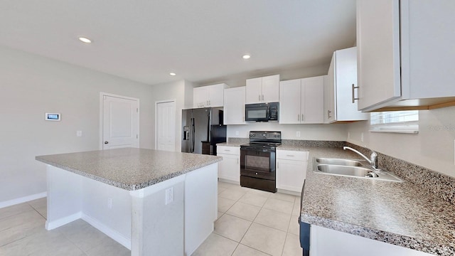 kitchen featuring sink, light tile patterned floors, a center island, black appliances, and white cabinets