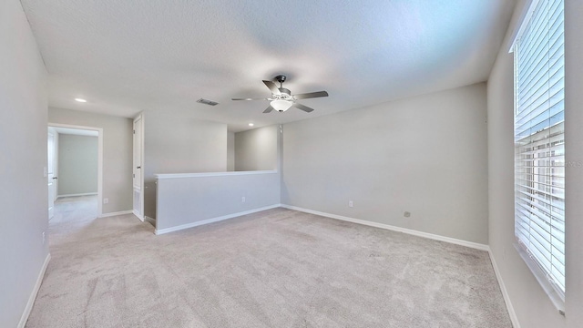 carpeted empty room with a textured ceiling and ceiling fan