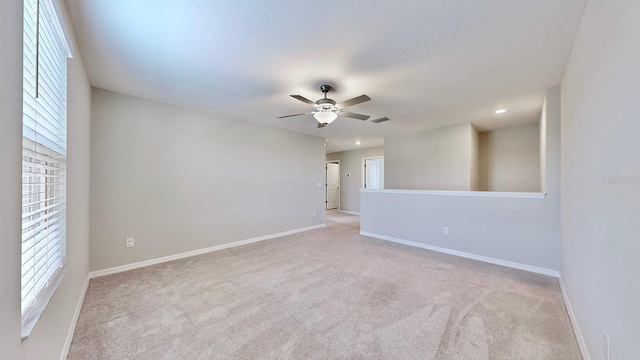 carpeted spare room featuring ceiling fan and a textured ceiling