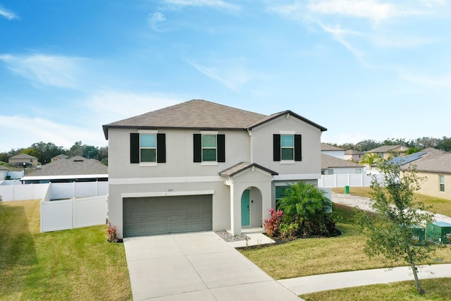 view of property with a garage and a front lawn