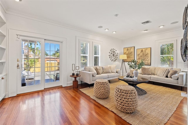 living room with hardwood / wood-style flooring and crown molding