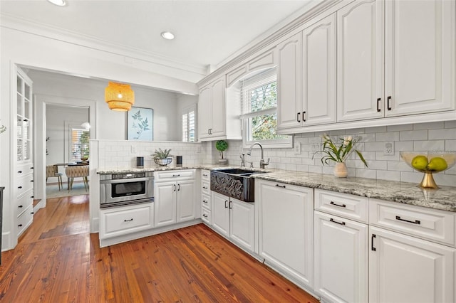 kitchen with ornamental molding, sink, dark wood-type flooring, and white cabinets