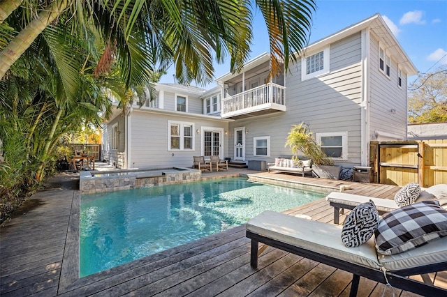 view of pool featuring an outdoor living space, a wooden deck, and a jacuzzi