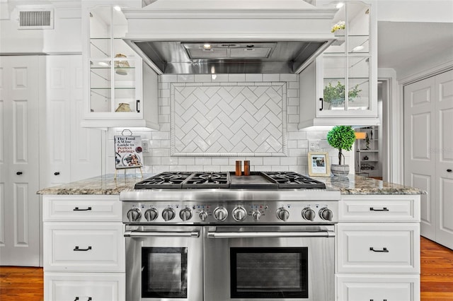 kitchen featuring white cabinetry, double oven range, light stone countertops, and custom exhaust hood