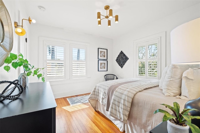 bedroom featuring hardwood / wood-style flooring and an inviting chandelier