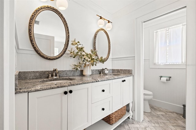 bathroom with vanity, ornamental molding, and toilet