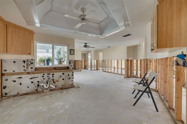 miscellaneous room featuring a raised ceiling and ceiling fan