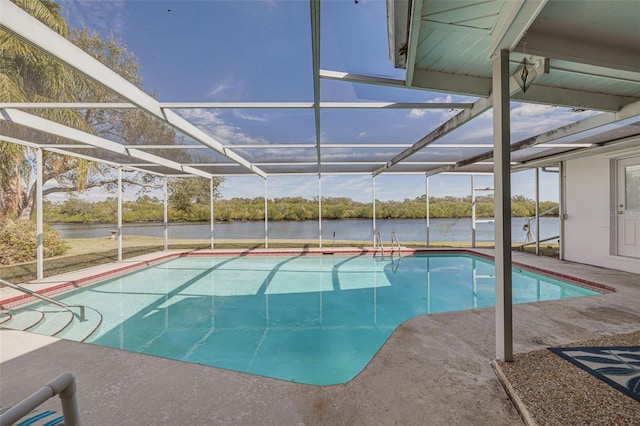 view of pool featuring a patio area, a water view, and glass enclosure