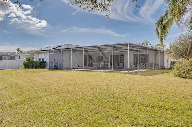 rear view of property with a swimming pool, a yard, and a lanai