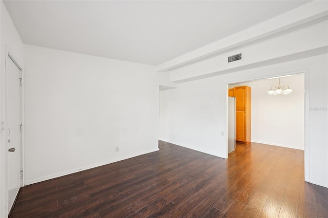 unfurnished room featuring dark hardwood / wood-style flooring and a chandelier