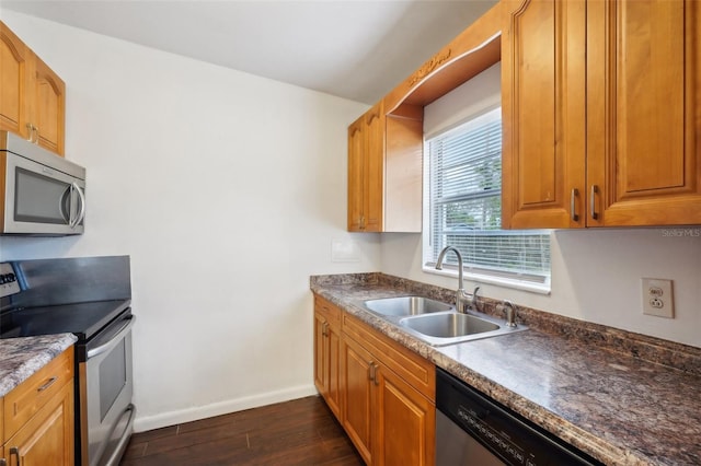 kitchen featuring stainless steel appliances, sink, and dark hardwood / wood-style floors