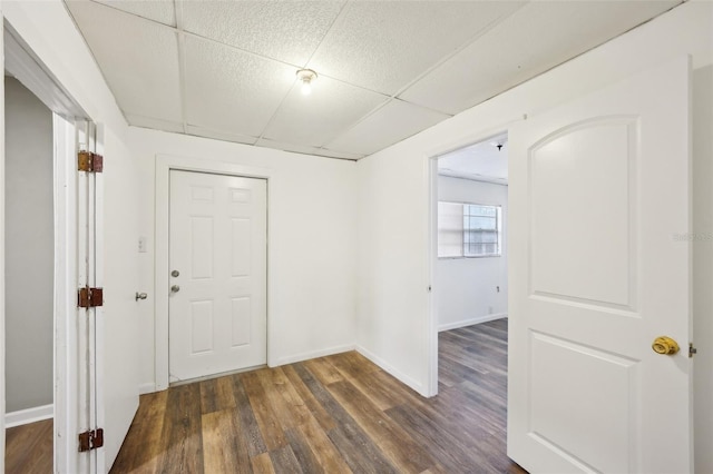 interior space with dark wood-type flooring and a drop ceiling