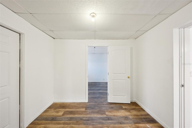 unfurnished room featuring a paneled ceiling and dark hardwood / wood-style flooring