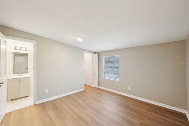 spare room with sink and light hardwood / wood-style floors