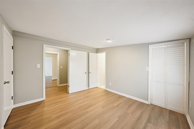 unfurnished bedroom with light hardwood / wood-style floors and a closet