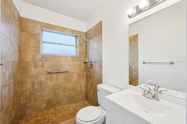 bathroom featuring tiled shower, vanity, and toilet