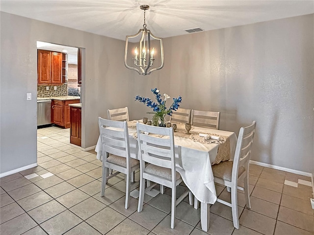 tiled dining area featuring an inviting chandelier