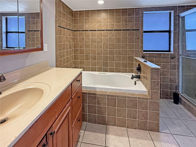 bathroom with tile patterned floors, vanity, independent shower and bath, and a textured ceiling