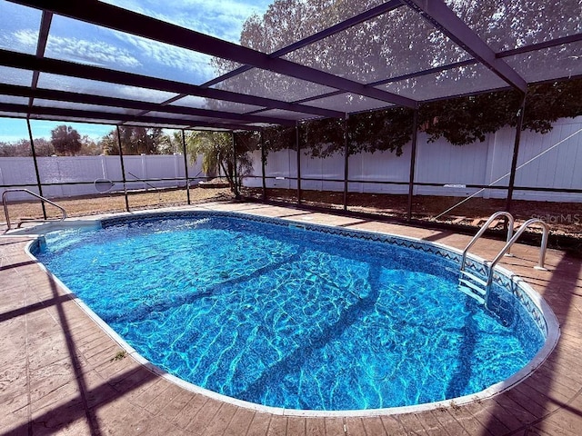 view of pool featuring glass enclosure and a patio area