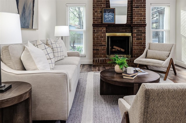 living room with a brick fireplace and hardwood / wood-style flooring