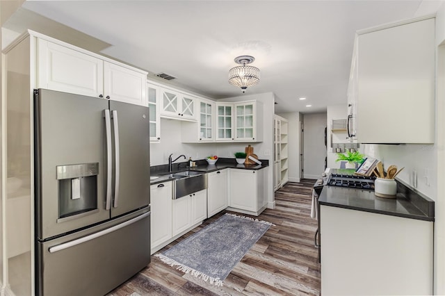 kitchen with stainless steel appliances, white cabinetry, sink, and dark hardwood / wood-style flooring