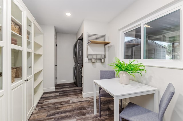 walk in closet with stacked washer and dryer and dark hardwood / wood-style floors