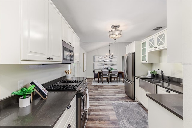 kitchen with sink, decorative light fixtures, a chandelier, appliances with stainless steel finishes, and white cabinets