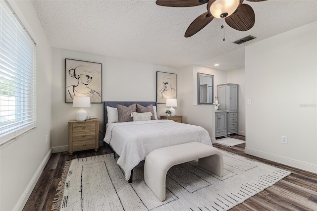 bedroom featuring a textured ceiling, dark wood-type flooring, and ceiling fan