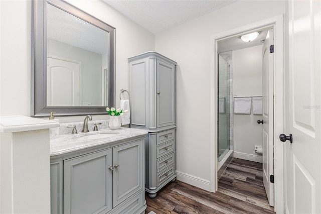 bathroom featuring an enclosed shower, vanity, hardwood / wood-style flooring, and toilet