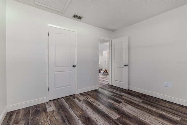 unfurnished room with dark hardwood / wood-style floors and a textured ceiling