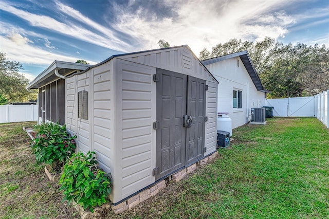 view of outbuilding with central AC and a lawn