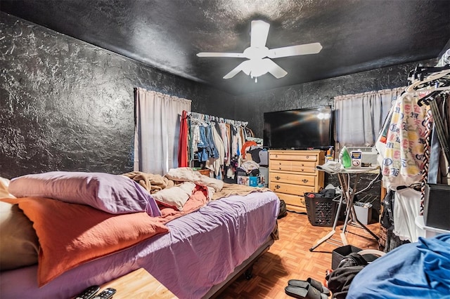 bedroom featuring parquet flooring, a textured ceiling, and ceiling fan