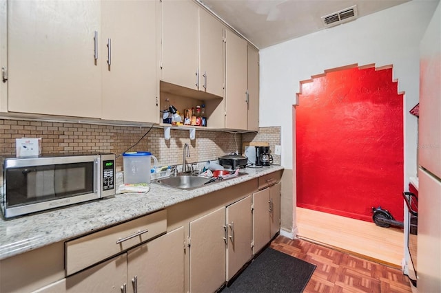 kitchen with dark parquet flooring, sink, oven, and decorative backsplash