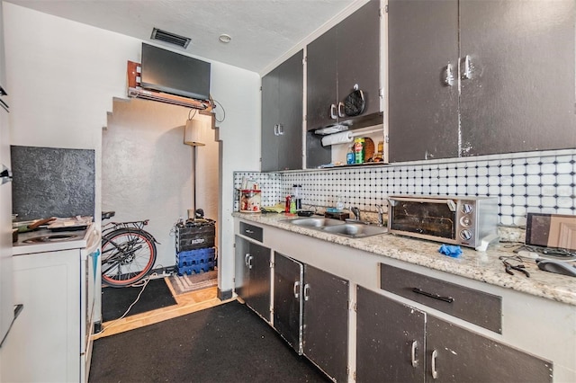 kitchen featuring tasteful backsplash, sink, exhaust hood, and white gas range oven