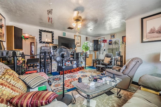 living room featuring ceiling fan and a textured ceiling