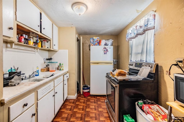 kitchen featuring white cabinetry, white fridge, dark parquet flooring, and stainless steel range with electric stovetop