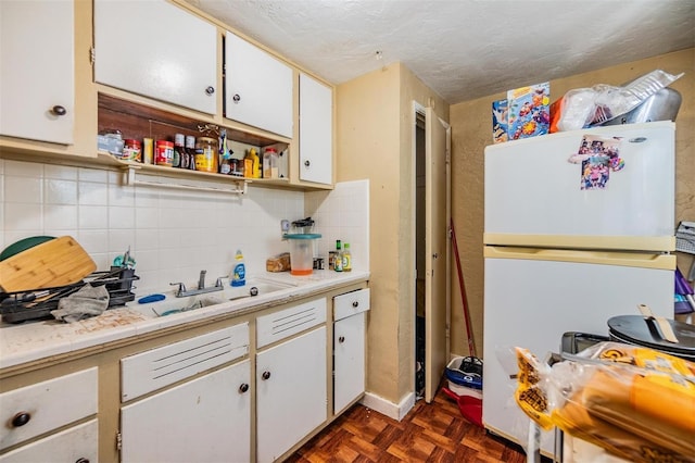 kitchen featuring white refrigerator, white cabinets, and dark parquet floors