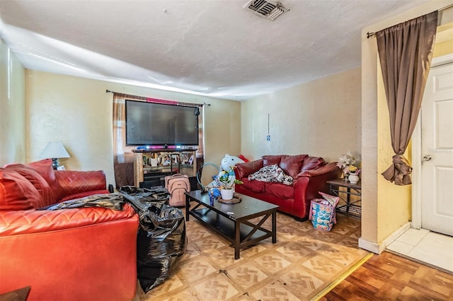 living room featuring parquet flooring and a textured ceiling