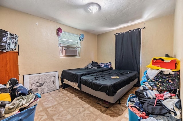 bedroom with cooling unit, a textured ceiling, and light parquet floors