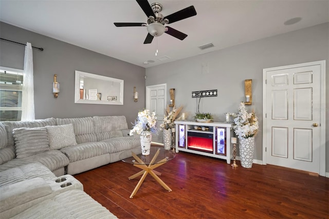 living room with dark hardwood / wood-style flooring and ceiling fan