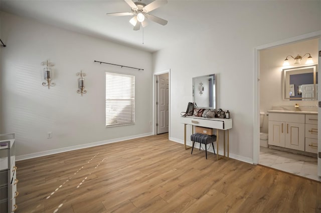 bedroom featuring ceiling fan, ensuite bath, and light hardwood / wood-style flooring