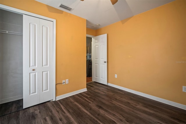 unfurnished bedroom featuring dark wood-type flooring, a closet, and ceiling fan