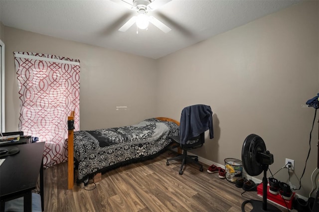 bedroom featuring ceiling fan, hardwood / wood-style floors, and a textured ceiling